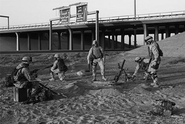 U.S. Marines of Weapons Platoon, Company E, 2d Battalion, 1st Marine Regiment, dig in while they wait to go in and patrol the city of Fallujah, Iraq, during Operation Vigilant Resolve.